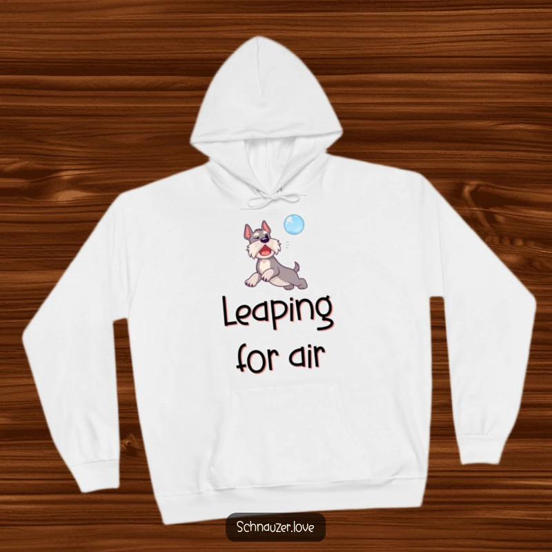 Funny hoodie depicting a schnauzer dog mid-leap, playfully reaching for a floating bubble.
