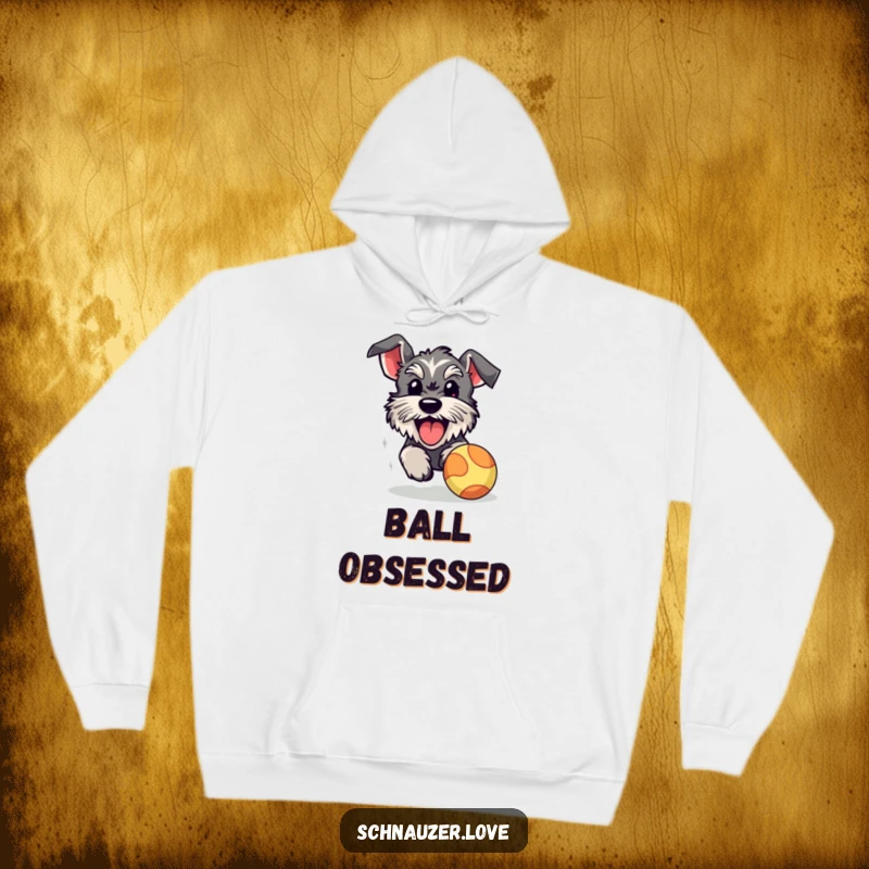 Funny schnauzer hoodie, a fluffy dog with its tongue out, enthusiastically chasing a bouncy ball, embodying pure playful energy.